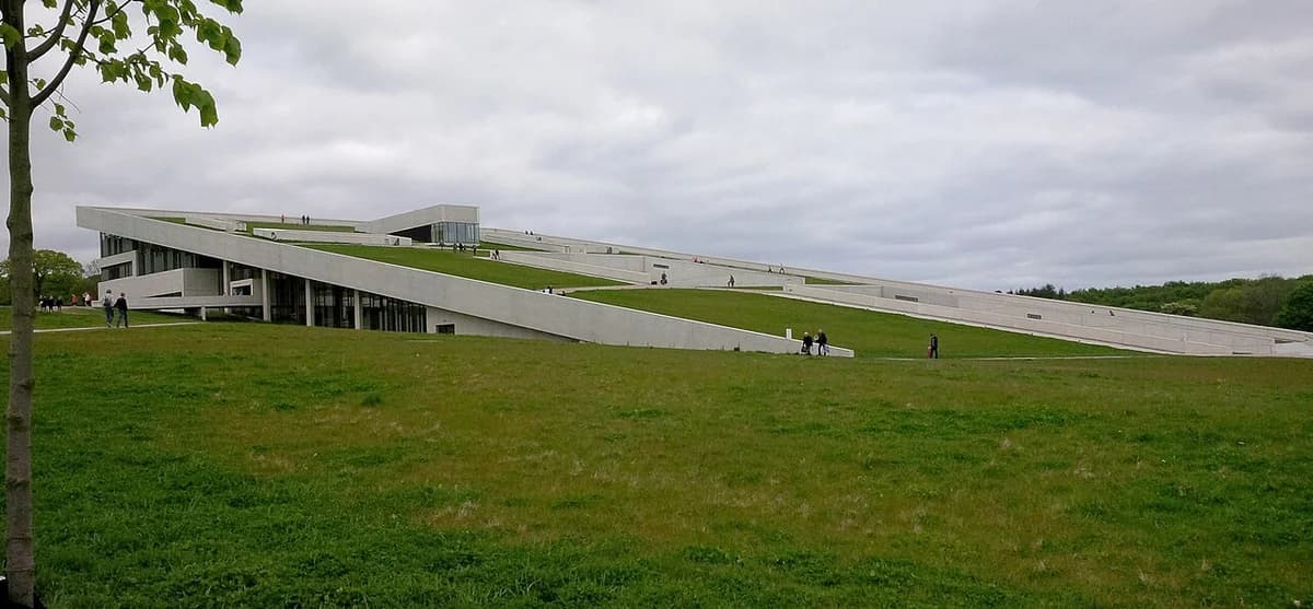 Wide view of the Moesgaard Museum in Aarhus with its sloped green roof and modern architecture.