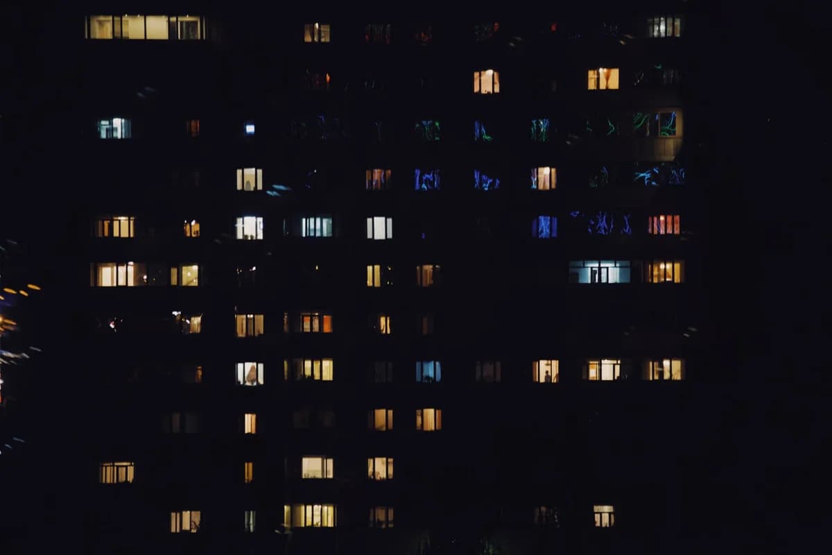 An apartment building at night with many illuminated windows.