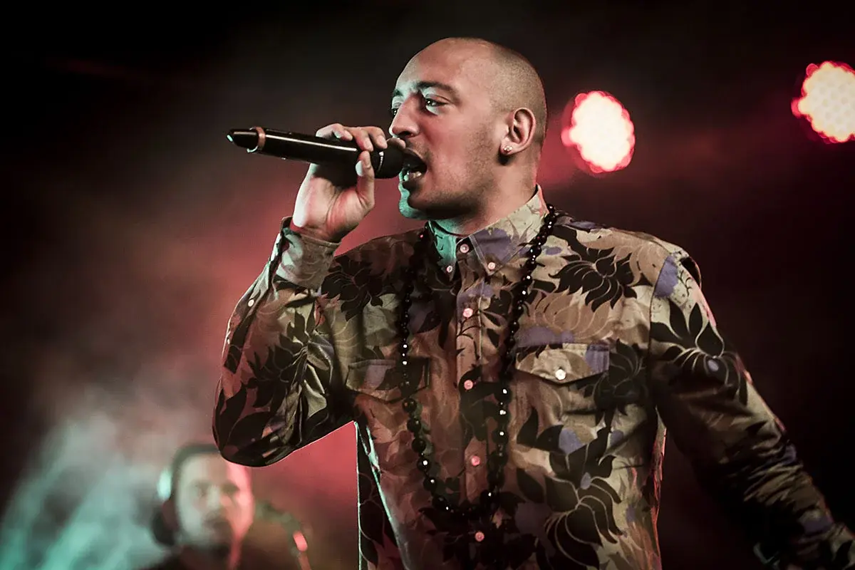 Wafande singing on stage during a live performance.