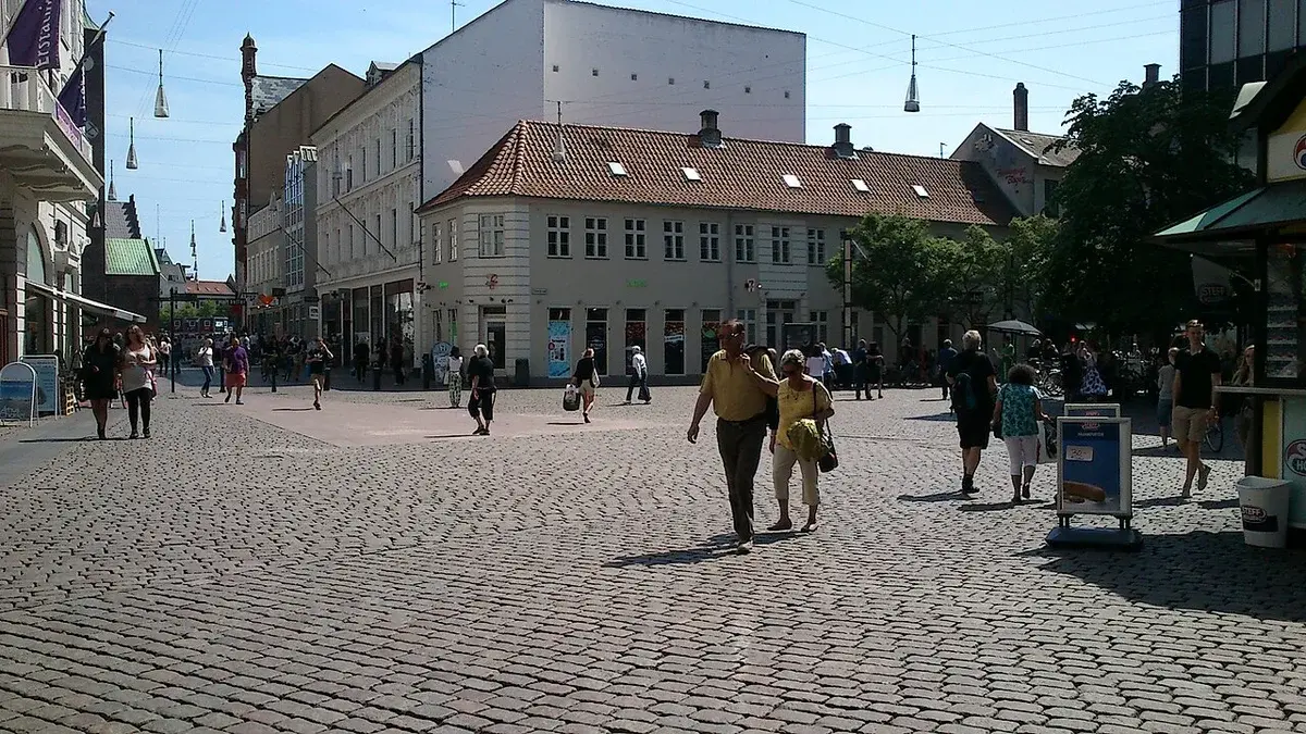 Cobblestone town square with people walking and traditional buildings