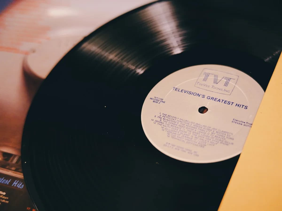 A vinyl record labeled "Television's Greatest Hits" on a turntable.