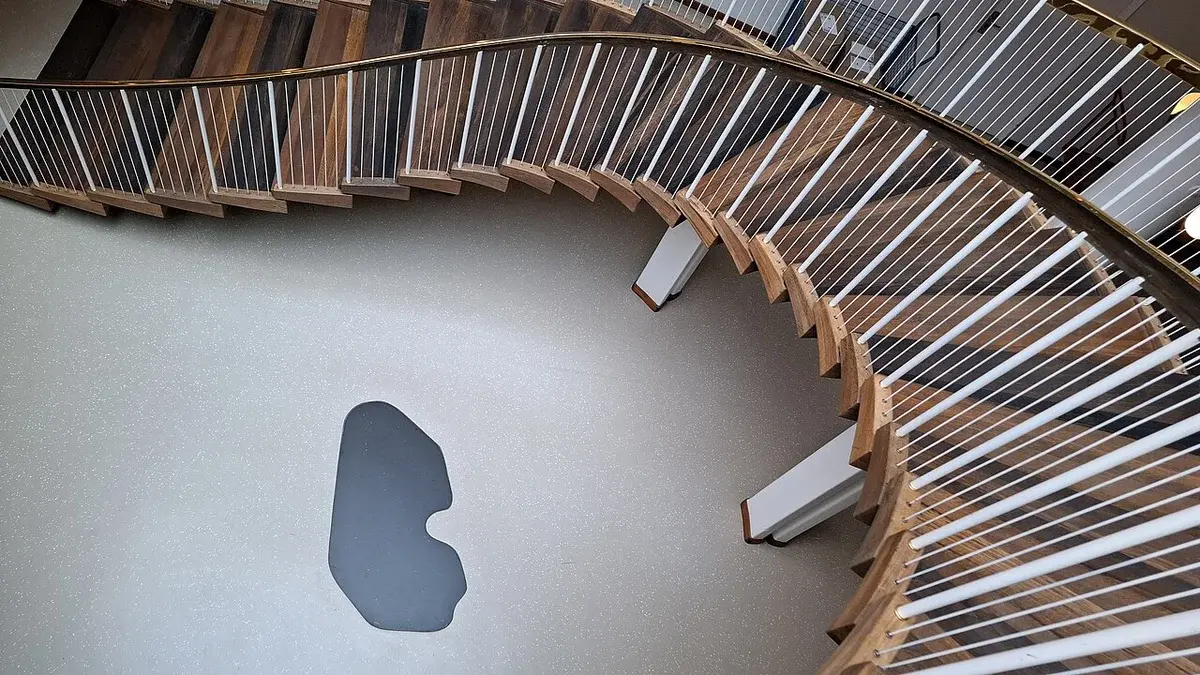 Interior spiral staircase in Aarhus City Hall with a visible foundation stone below.