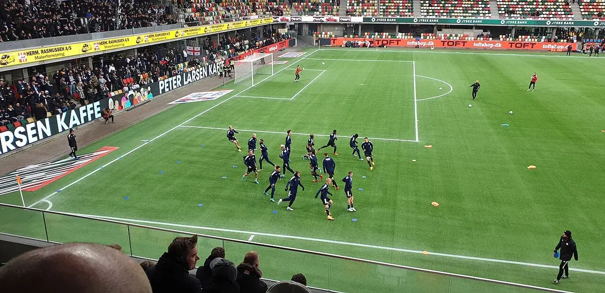 FC Copenhagen players warming up on the pitch before a match.