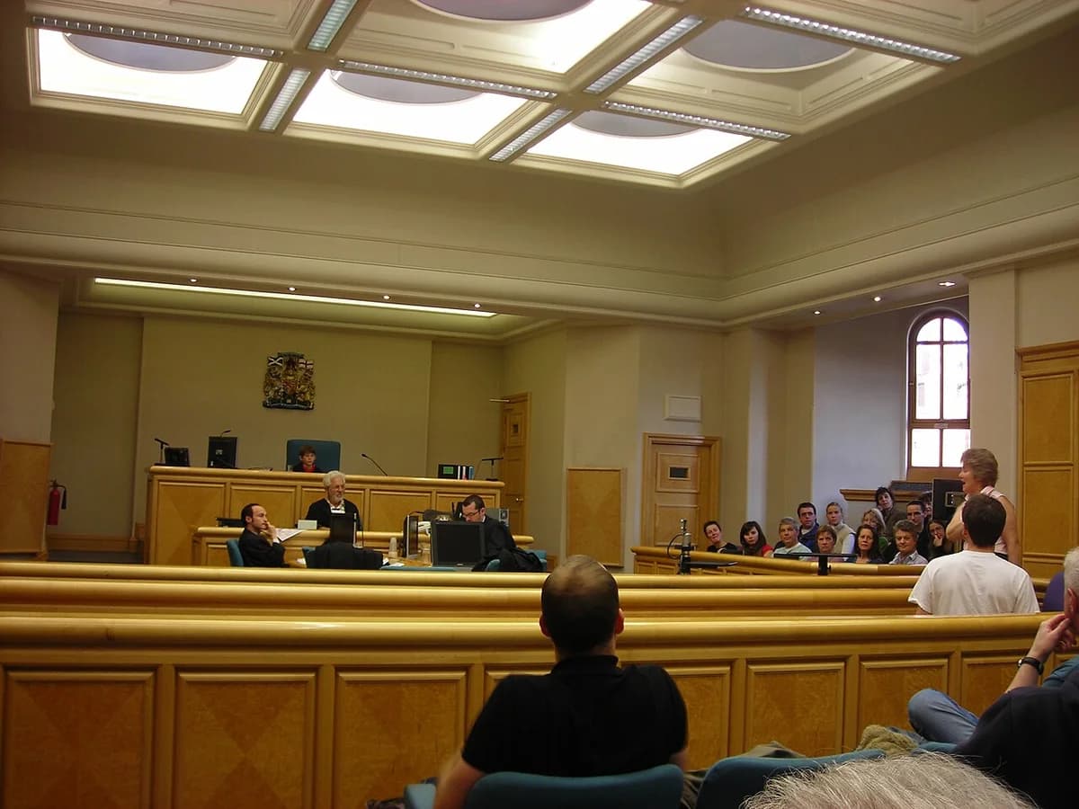 A courtroom in Edinburgh Sheriff Court with people seated and staff at the front.