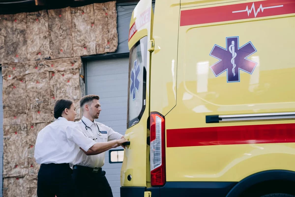Two paramedics closing ambulance rear door
