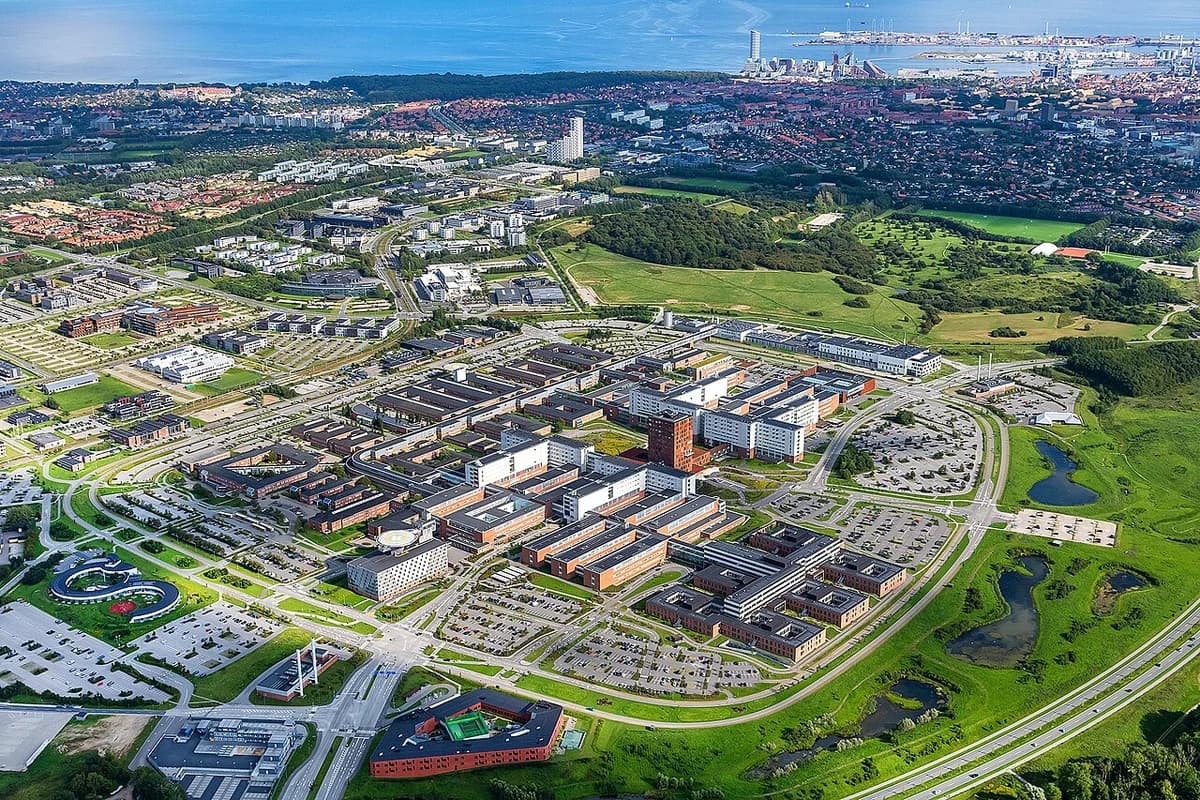 Aerial view of Aarhus University Hospital and surrounding coastal city in summer