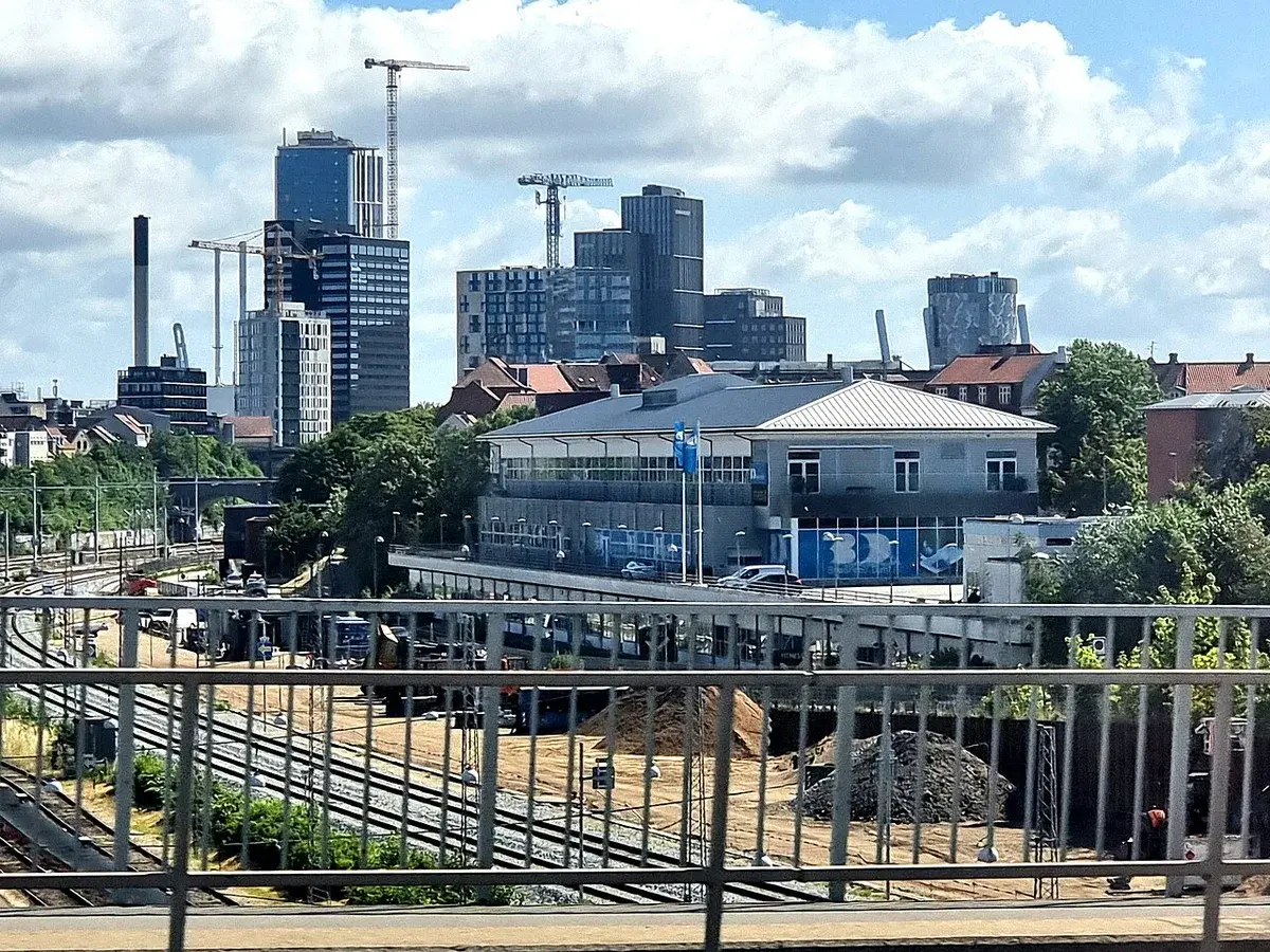 Daytime skyline of Aarhus with modern buildings and railway tracks.