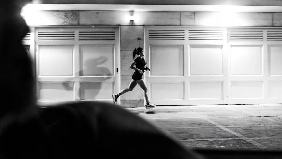 A woman runs at night along a street in Buenos Aires.