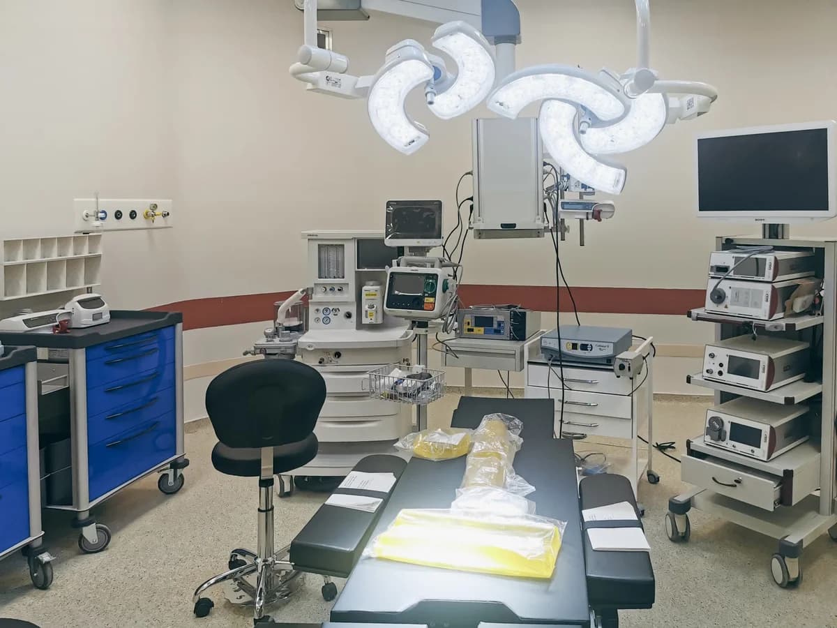 A modern operating room with an operating table, surgical lights, and medical equipment.