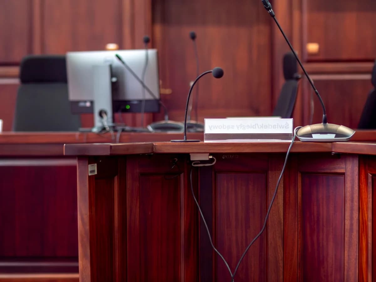 Wooden podium with microphones and nameplate in courtroom