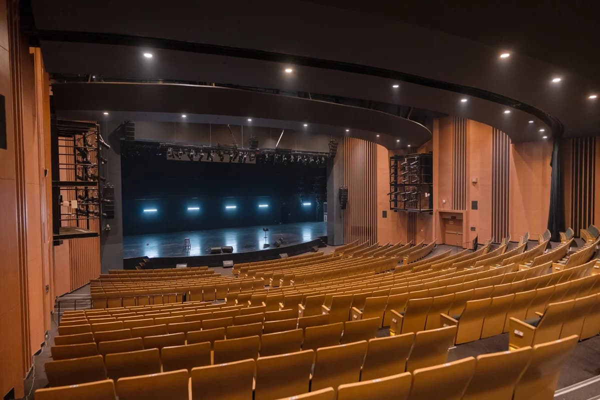 Empty theater with rows of wooden seats and a stage